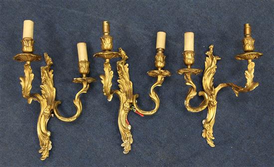 A set of three Louis XV style gilt metal two branch wall lights, 12in.